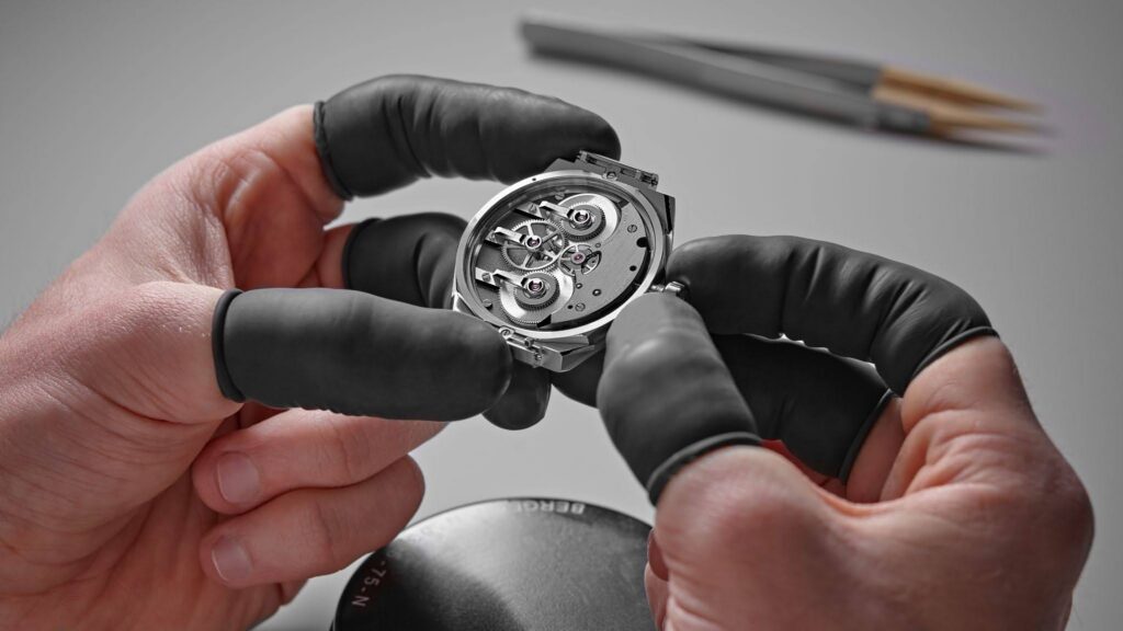 A watchmaker assembling a movement in the Biel atelier. Twenty years on from the Berkshire chicken shed, every Christopher Ward is still built by hand in Switzerland.